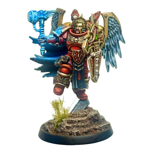 CT Miniatures UK Jetpack Captain miniature with ornate wings, gold shield, blue hammer, and red armor. Designed for 32-40mm bases.