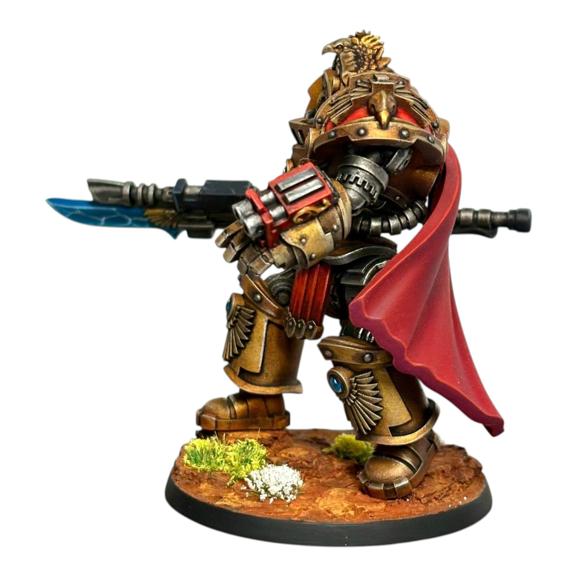 CT Miniatures UK Reliquia Spaciator miniature, a gold and red armored figure with a blue energy sword and red cape, on a textured base.