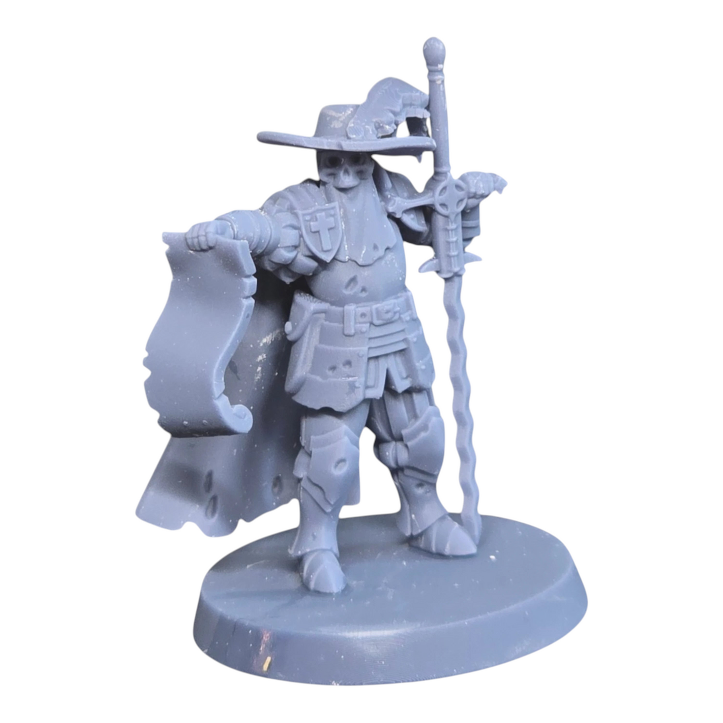 CT Miniatures UK Inquisitor miniature, grey resin, holding scroll and sword, wearing hat and armor.